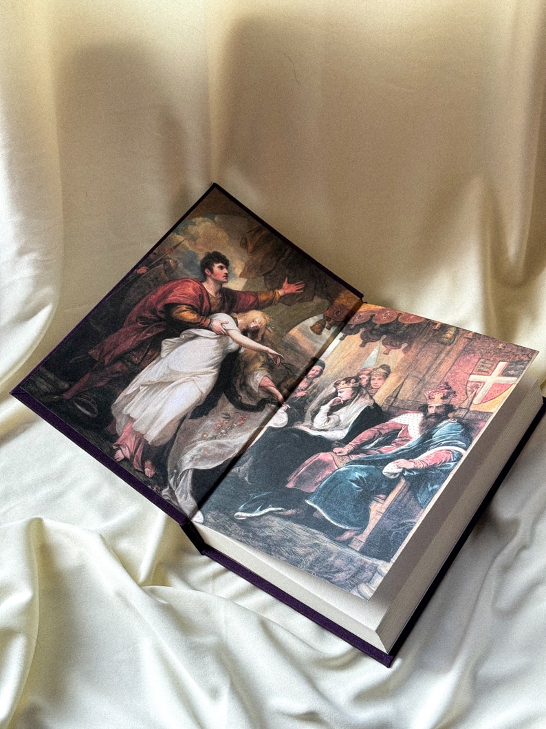 May include: An open book with two illustrations. The left page shows a man in red and gold clothing holding a woman in a white dress. The right page shows a group of people in medieval clothing, including a king sitting on a throne.