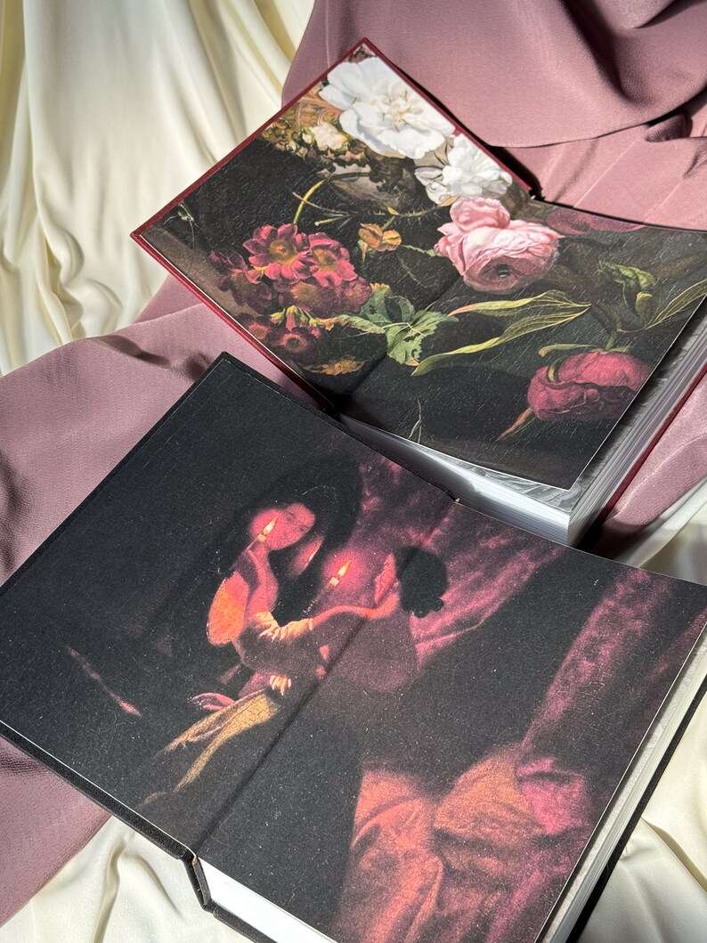 Puede incluir: Dos libros de tapa dura con diferentes cubiertas. El primer libro tiene un dise&ntilde;o floral con flores rosas, blancas y rojas sobre un fondo oscuro. El segundo libro tiene un fondo oscuro con una pintura de dos personas sosteniendo velas.