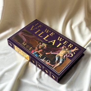 May include: A purple hardback book with gold lettering titled "If We Were Villains" by M.L. Rio. The cover features a painting of a group of people in a dramatic scene.