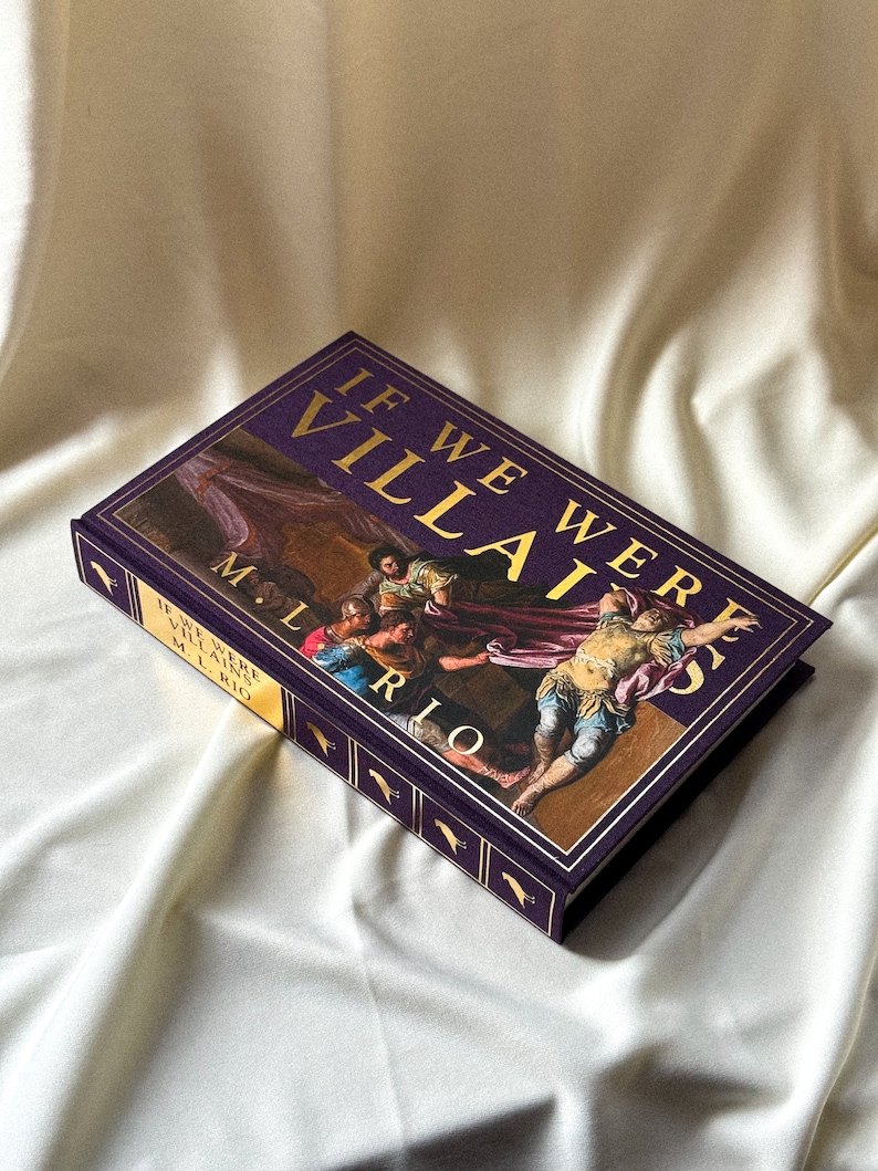 May include: A purple hardback book with gold lettering titled "If We Were Villains" by M.L. Rio. The cover features a painting of a group of people in a dramatic scene.