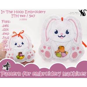 May include: Embroidered bunny-shaped treat bag with a pink nose, pink ears, and pink paws. The bag has a clear window to see the treats inside. The design is for embroidery machines and comes in three sizes: 4x4, 5x7, and 6x10 inches. Files included are: .pes, .dst, .exp, .hus, jef, vip, and .xxx.