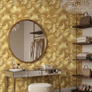 a luxurious dressing room with a gold floral wallpaper, a round mirror, a vanity with drawers, and a chandelier.