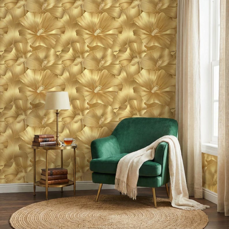 a cozy living room with a green armchair, a side table with a lamp and books, and a large gold floral wallpaper.