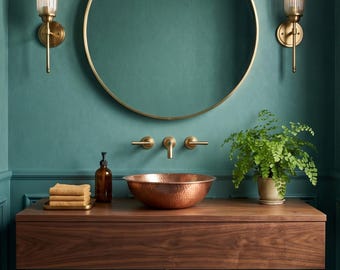 Può includere: Un mobile da bagno con un mobile sospeso in legno scuro, un lavabo in rame martellato e un rubinetto a parete in ottone. Sopra il lavabo si trova un grande specchio rotondo con cornice in ottone, affiancato da due applique in vetro.