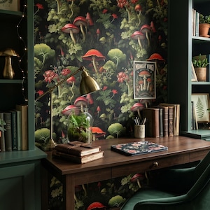K&ouml;nnte beinhalten: Ein gem&uuml;tliches Heimb&uuml;ro mit einem dunklen Holzschreibtisch, einem gr&uuml;nen Samtstuhl und einer Tapete mit Pilzmotiven. Eine Messing-Schreibtischlampe beleuchtet ein Terrarium und B&uuml;cher. Ein gerahmter Druck und ein Poster mit dem Text "MIDNIGHT FUNGI" sind ebenfalls zu sehen.