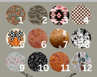 May include: A collection of car coasters with various designs, including floral, camouflage, geometric patterns, and a pumpkin. The coasters are round and feature a western theme, with the text "Boots and Buckless" and a steer skull graphic.