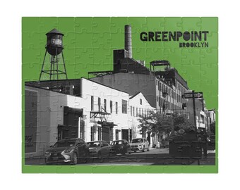 May include: A black and white photograph of a city street scene in Greenpoint, Brooklyn. The image features a water tower, brick buildings, and cars parked on the street. The text "GREENPOINT BROOKLYN" is displayed in the upper right corner of the image.