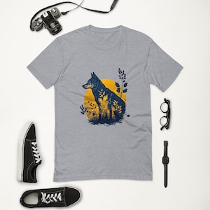 May include: A heather grey t-shirt with a blue silhouette of a wolf sitting in front of a yellow sun and green foliage.