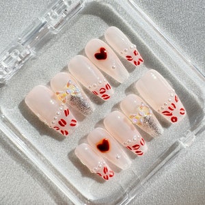 Hugs and kisses press on nails. With pearls and bow, little love heart. Such an adorable set.