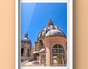 Puede incluir: Una fotografía enmarcada en blanco de la Basílica de San Pedro en Roma, Italia. La foto muestra la cúpula de la basílica y una parte del techo. El cielo es azul y el sol brilla.