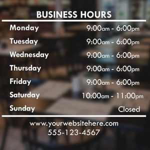 May include: White text on a blurred background displays business hours. The sign lists hours for each day of the week, including opening and closing times, and contact information.