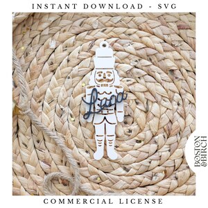 May include: A white wooden nutcracker ornament with the name "Liza" in a dark color. The ornament is on a woven background. Text at the top reads "INSTANT DOWNLOAD - SVG" and at the bottom "COMMERCIAL LICENSE".