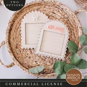 Puede incluir: Dos marcos de madera con bordes festoneados. Un marco tiene un lazo blanco y el otro tiene el texto "Mrs. Jones" en rosa.