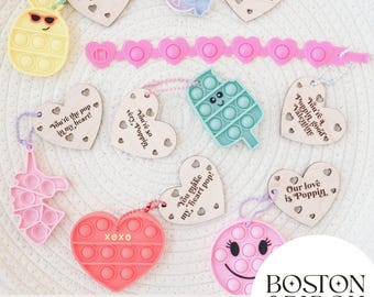 Puede incluir: Un conjunto de 10 etiquetas de madera en forma de corazón cortadas con láser con varios mensajes para el Día de San Valentín. Cada etiqueta presenta un juguete pop-it fidget en un color y diseño diferente. Las etiquetas son perfectas para agregar un toque divertido y juguetón a tus regalos del Día de San Valentín.