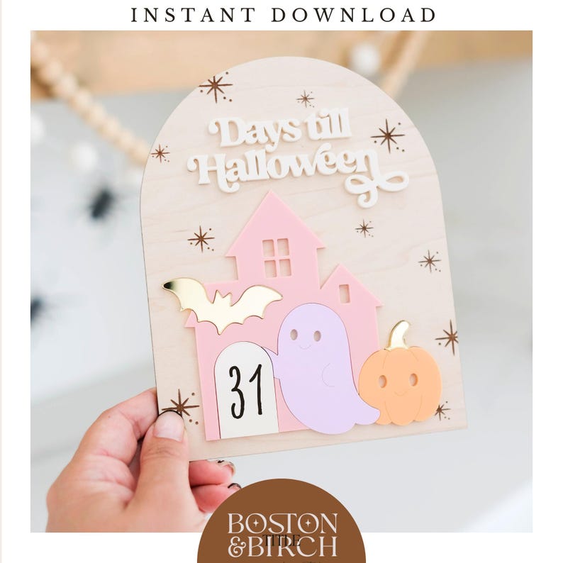 May include: Wooden Halloween countdown sign with a pink house, a purple ghost, and an orange pumpkin. The sign reads "Days till Halloween" and displays the number "31". Decorative gold stars and a gold bat are also featured.