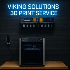 May include: A 3D printer with the text "VIKING SOLUTIONS 3D PRINT SERVICE" in neon blue. The printer is black and silver, with a display screen. Above the printer are spools of filament in various colors. The background is a dark brick wall.