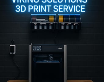 May include: A 3D printer with the text "VIKING SOLUTIONS 3D PRINT SERVICE" in neon blue. The printer is black and silver, with a display screen. Above the printer are spools of filament in various colors. The background is a dark brick wall.
