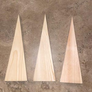 May include: Three unfinished wooden triangle shapes, each with a different grain pattern. The triangles are approximately 6 inches tall and 4 inches wide.