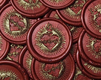 Könnte beinhalten: Eine Ansammlung roter Wachssiegel mit einem goldenen Herzmotiv. Jedes Siegel zeigt ein Herz, das von einer Dornenkrone umgeben ist, mit Flammen darüber und Strahlen, die nach außen gehen. Die Siegel sind kreisförmig und glänzend.