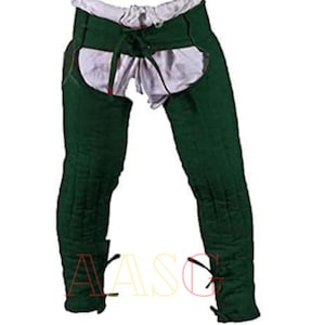 Puede incluir: Armadura de pierna de tela acolchada verde con cinturón y correas con cordones. La armadura está diseñada para proteger las piernas y los muslos.