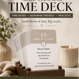 Könnte beinhalten: Ein Kartenspiel für die Reinigung bei ADHS, mit dem Text "TIME DECK". Die Karten werden in einem Holzhalter präsentiert. Eine Karte lautet "15 MINUTE CLEAN" mit Anweisungen, sich auf einen Bereich zu konzentrieren und einen Timer für 15 Minuten einzustellen. Das Deck ist mit "ADHD FRIENDLY" gekennzeichnet.