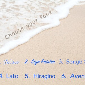 Pu&ograve; includere: Una scena di spiaggia con onde bianche e spumose che si infrangono sulla sabbia. Il testo "Choose your font" &egrave; scritto sulla sabbia. Sotto il testo sono elencati sei nomi di font con numeri: 1. Shalimar, 2. Sign Painter, 3. Songti SC, 4. Lato, 5. Hiragino, 6. Avenir.