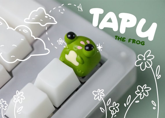 A hand-cast resin frog artisan keycap with kawaii-core green-pink coloring — exactly the kind of tiny sculpted desk art that mechanical keyboard obsessives go wild for, and 366 favorites proves it.