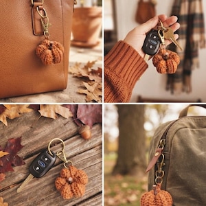 May include: A small, crocheted pumpkin keychain in a burnt orange color with a dark brown stem. The pumpkin is attached to a gold-toned metal lobster clasp and a circular key ring, shown hanging from a leather bag, a backpack, and with keys.