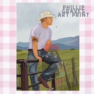 May include: A man wearing a white cowboy hat and a white t-shirt with a tattoo on his arm is sitting on a wooden fence. He is looking off to the side and there are mountains in the background. The text "Phillip Graves Art Print" is at the top of the image.