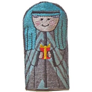 May include: A finger puppet of a person wearing a blue robe and holding a red gift box. The person has a blue head scarf and a smiling face.