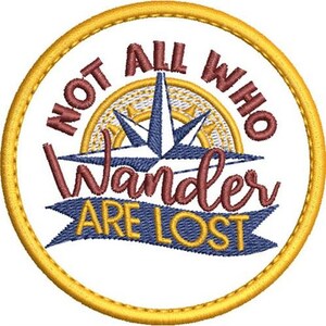 Puede incluir: Un parche redondo bordado de color amarillo con un diseño de rosa de los vientos y el texto "Not all who wander are lost".