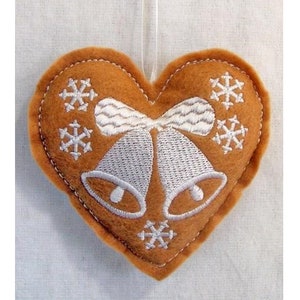 Op de afbeelding: Een bruin vilten hartvormig ornament met witte geborduurde sneeuwvlokken, bellen en een strik.