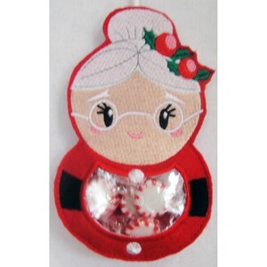 May include: Red felt Christmas stocking with a clear plastic window, featuring an embroidered image of a smiling woman with white hair, wearing glasses and a red dress with a black belt. The stocking is filled with candy.