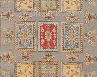 May include: A rectangular gray rug with a repeating pattern of colorful rectangular panels. Each panel features intricate floral and geometric designs in yellow, red, blue, and green. The rug's border is adorned with floral motifs.