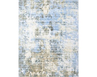 May include: Abstract area rug with a blue, beige, and white color scheme. The rug has a distressed, faded look with a subtle pattern.