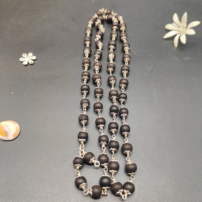 Close-up of Black Ebony Karungali Mala showing smooth polished 8mm beads and German silver spacers.