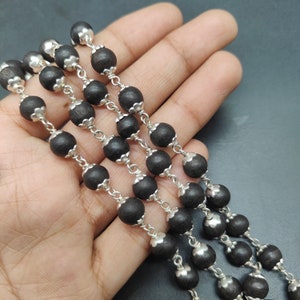 Handheld photo showing bead size and natural finish.