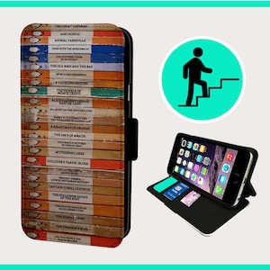 Op de afbeelding: Een zwarte telefoonhoes met een ontwerp van boekruggen met titels zoals "The Great Gatsby", "Animal Farmville", "Gone with the Windows XP", "The Old Man and the Bae", "Of Mice and Mennt", "A Tale of Two Twitters", "The Count of Monte Cristo", "Alice's Adventures in Bantier Land", "All Quiet on the Western Font", "Barry Autocracy and the Prisoners of Australian", "A Smartwatch Orange", "The Days of Wrath", "The Dmi's of Pictures", "The People Who", "Wuthering Likes", "Gulliver's Travel Blogs", "Love in the North", "Bridget Jones's Campsite", "Locked Instagram Account", "Captain Corelli's Synth", "The Follower Count of the Ring", "The Statue Edictates of Buckleighington", "The Kinder Three", "The Timehop's Wife", "The Style People You Will In March", "The Tumen of"