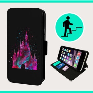 Puede incluir: Funda de teléfono negra con un diseño de castillo en acuarela colorida. La funda está abierta, mostrando un teléfono inteligente con iconos de aplicaciones y ranuras para tarjetas. Un círculo verde con una persona subiendo una escalera está en el fondo.