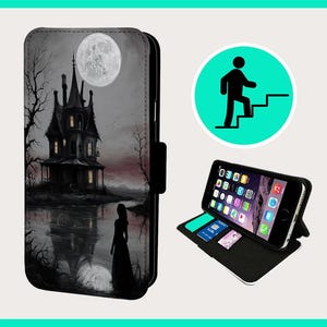 May include: A black phone case featuring a spooky illustration of a haunted house, a full moon, and a woman standing in front of a lake. The case has a flap that covers the phone screen.