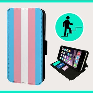 Puede incluir: Una funda de teléfono negra con un diseño de bandera del orgullo transgénero. La funda tiene un soporte y una ranura para tarjetas.