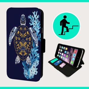 Könnte beinhalten: Eine blaue Handyhülle mit einem goldenen und blauen Meeresschildkröten-Design. Die Schildkröte ist von blauem und weißem Korallen umgeben. Die Hülle ist geschlossen und geöffnet dargestellt, wobei eine schwarze Handyhülle mit einem Kartensteckplatz sichtbar wird.