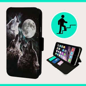May include: A black leather phone case with a graphic of three wolves howling at the moon. The case has a stand feature and a flap that closes with a magnetic clasp.