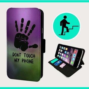 May include: A black phone case with a purple, green, and blue ombre design. A black handprint with the text "Don't Touch My Phone" is printed on the case.