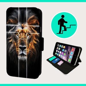 Può includere: Una custodia per telefono nera con un leone stampato su di essa. Il viso del leone è a fuoco e lo sfondo è sfocato. La custodia ha una patta che può essere ripiegata per proteggere lo schermo del telefono.