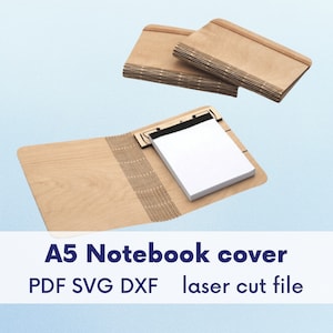 Op de afbeelding: A5 notitieboekhoes van lichtbruin hout. De open hoes toont een wit notitieblok. Twee extra hoezen zijn erbovenop gestapeld. De tekst "A5 Notebook cover PDF SVG DXF laser cut file" staat onderaan.