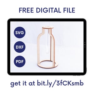 Op de afbeelding: Een digitaal beeld op een tablet toont een houten bloemknopvaas met een heldere glazen buis. De afbeelding bevat de tekst "FREE DIGITAL FILE" en pictogrammen voor SVG-, DXF- en PDF-formaten. De tekst "get it at bit.ly/3fCKsmb" is ook zichtbaar.