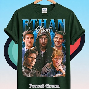 Może przedstawiać: Leśnozielony t-shirt z kr&oacute;tkim rękawem z nadrukiem graficznym przedstawiającym Ethana Hunta. Wz&oacute;r zawiera napis "ETHAN" dużymi niebieskimi literami oraz "Hunt" białą kursywą, z czterema r&oacute;żnymi wizerunkami postaci na tle niebieskich błyskawic.