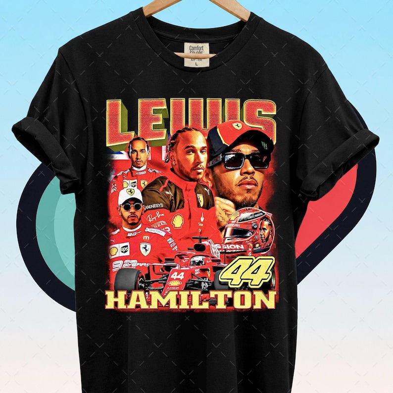Pode incluir: Camiseta preta com um gr&aacute;fico em estilo vintage de Lewis Hamilton com fato e capacete de corrida vermelhos. O design inclui os textos "LEWIS" e "HAMILTON" e o n&uacute;mero "44".