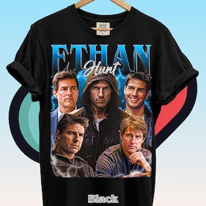 Może przedstawiać: Czarny t-shirt z kr&oacute;tkim rękawem z nadrukiem graficznym przedstawiającym pięć r&oacute;żnych wizerunk&oacute;w mężczyzny. Napis ETHAN jest wydrukowany dużymi niebieskimi literami u g&oacute;ry, a poniżej słowo Hunt białą kursywą. Obrazy otaczają błyskawice.